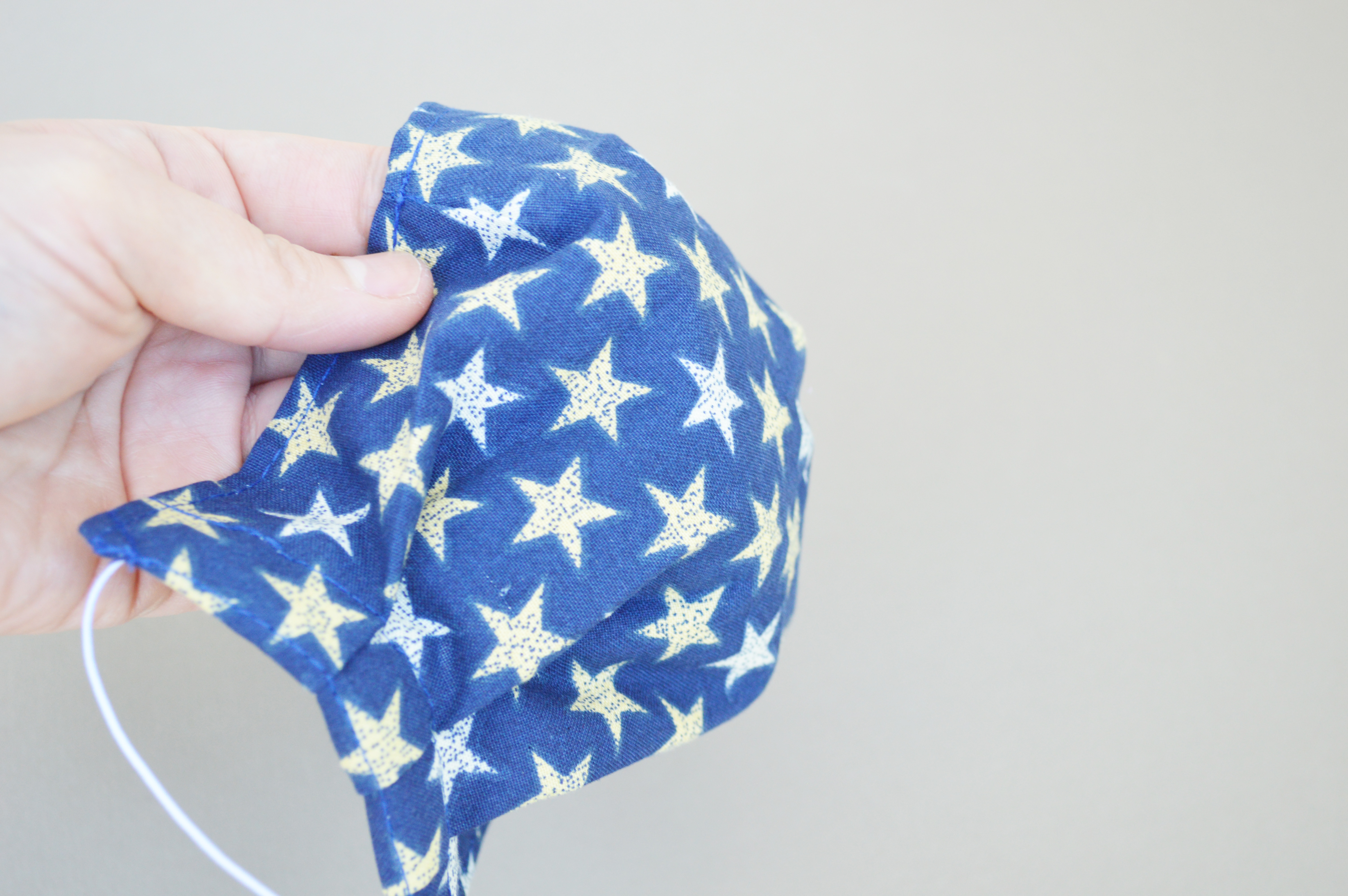 Image of blue cotton-fabric mask with white and gold star pattern
